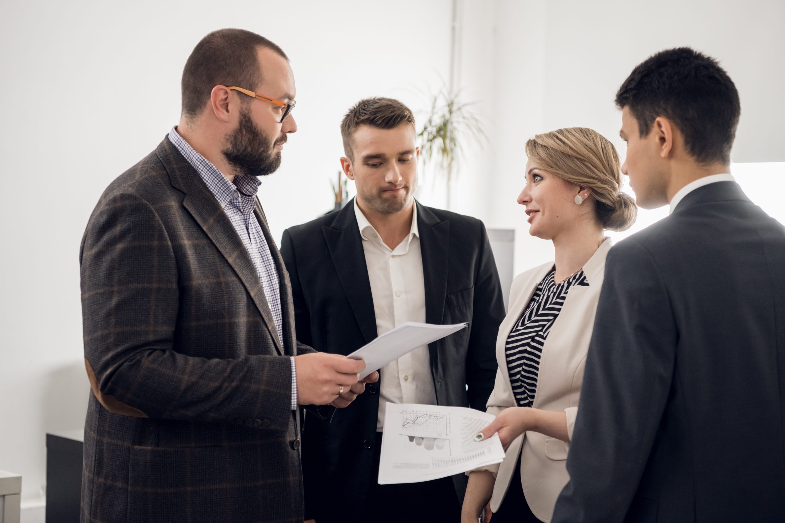The chief of the construction company holds a standing meeting with subordinates, gives instructions and demands a report on the work done in the office.